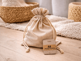 Owloo Master Buddies wooden educational toy stored in a natural fabric drawstring bag with challenge cards on a wooden floor