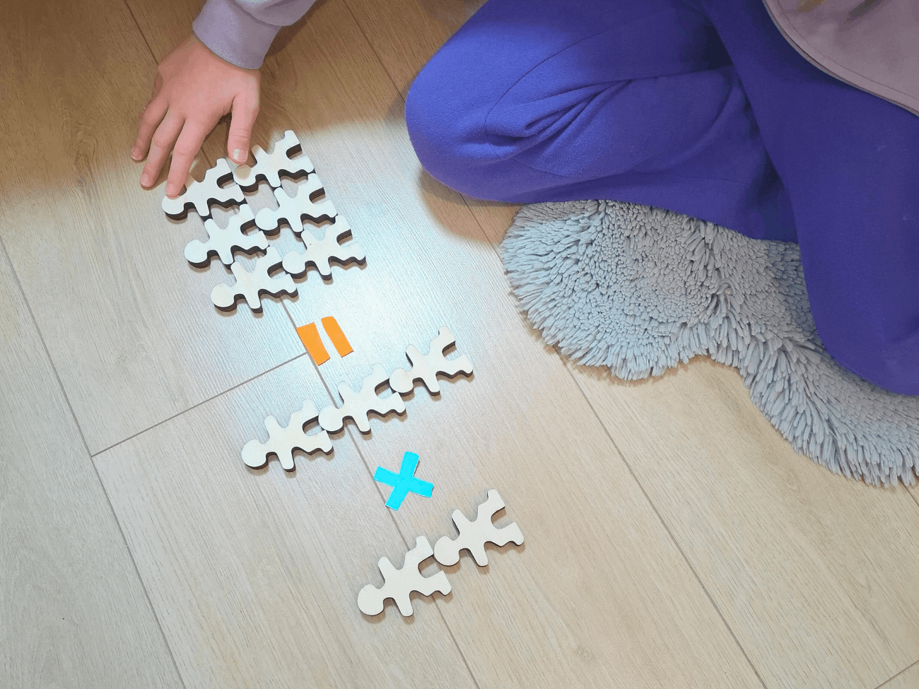 Owloo Master Buddies wooden balancing toy with a child building shapes on the floor