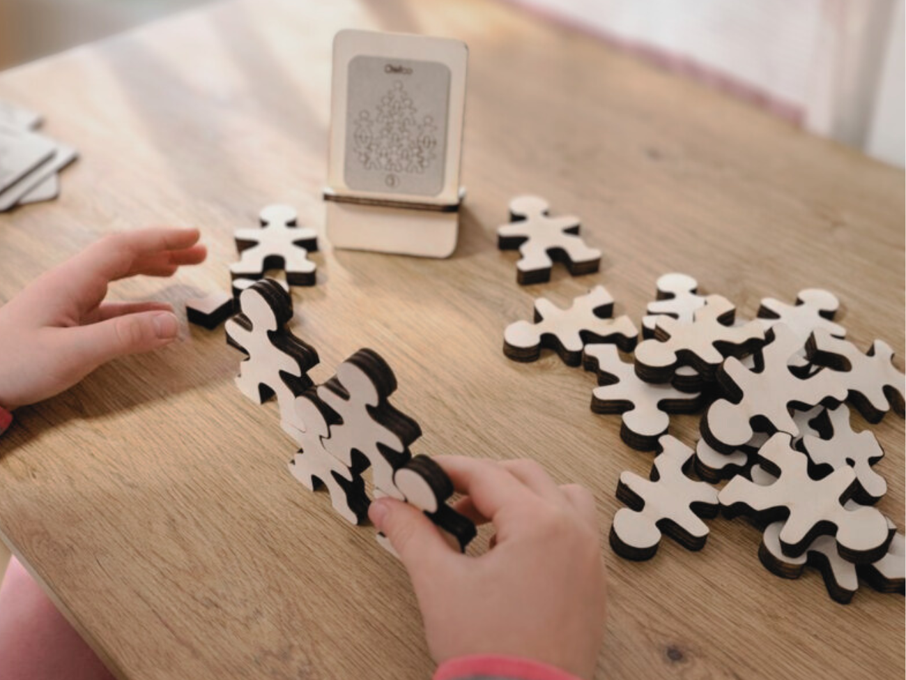 Owloo Master Buddies wooden balancing toy with a child building a balance structure using wooden figures