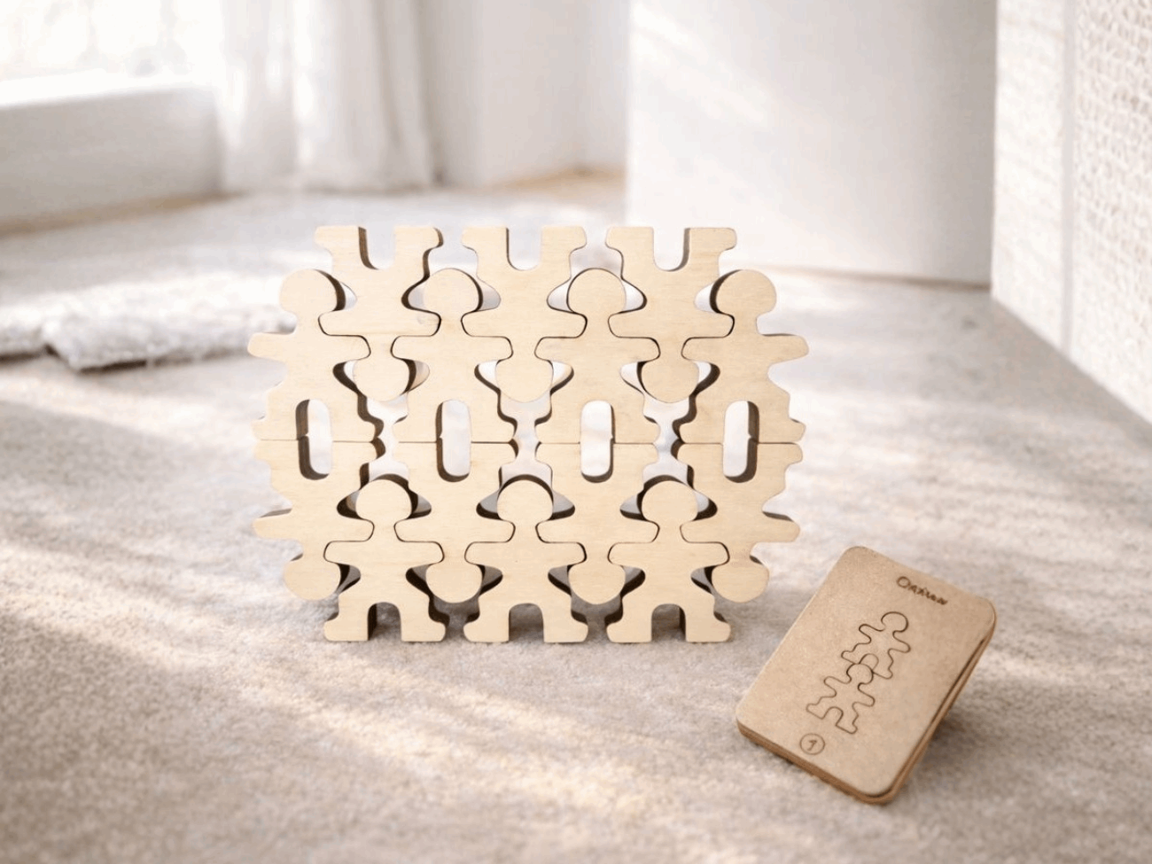Owloo Master Buddies wooden balancing toy with stacked wooden figures and a challenge card placed beside the structure