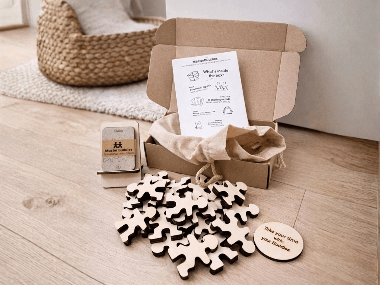 Owloo Master Buddies wooden toy set with challenge cards, storage bag and natural wooden figures displayed next to an open cardboard box