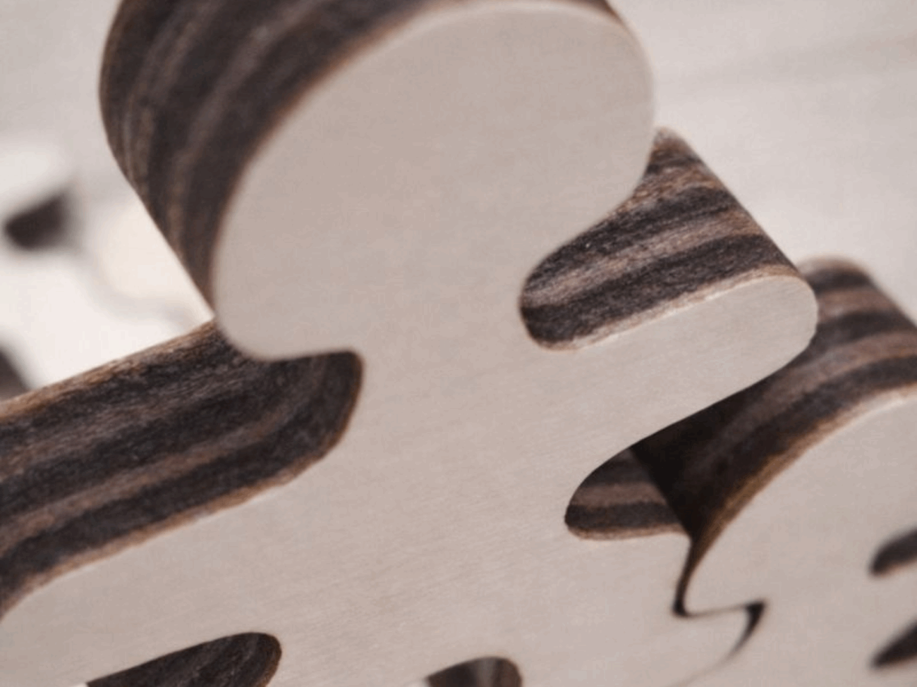 Close-up detail of Master Buddies wooden figure showing smooth natural wood surface and layered edges, highlighting craftsmanship and material quality