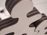 Close-up detail of Master Buddies wooden figure showing smooth natural wood surface and layered edges, highlighting craftsmanship and material quality